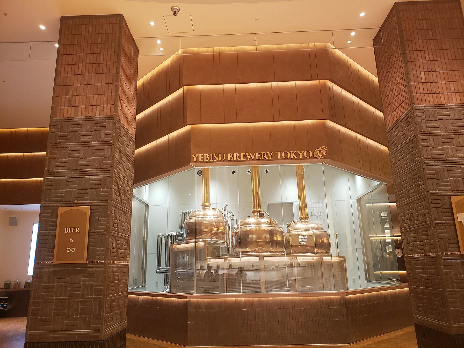 Inside YEBISU BREWERY TOKYO: the brewing kettles stand behind glass in a brick-lined hall (photographed on 2 April 2024, the day before it opened). Photo: Tokkyu Tokai / Wikimedia Commons / CC0