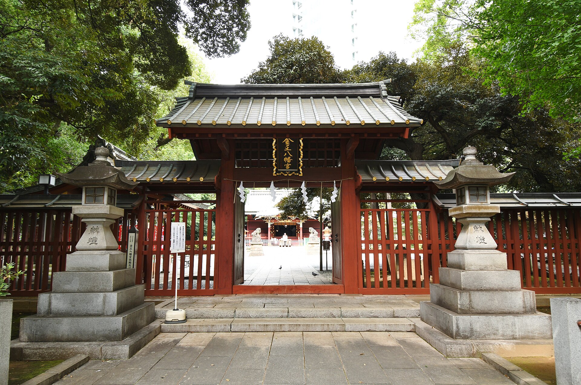 金王八幡宮の神門（通称・赤門）。石灯籠のあいだに朱塗りの門が立つ（2021年9月25日撮影）。写真：Saigen Jiro / Wikimedia Commons / CC0