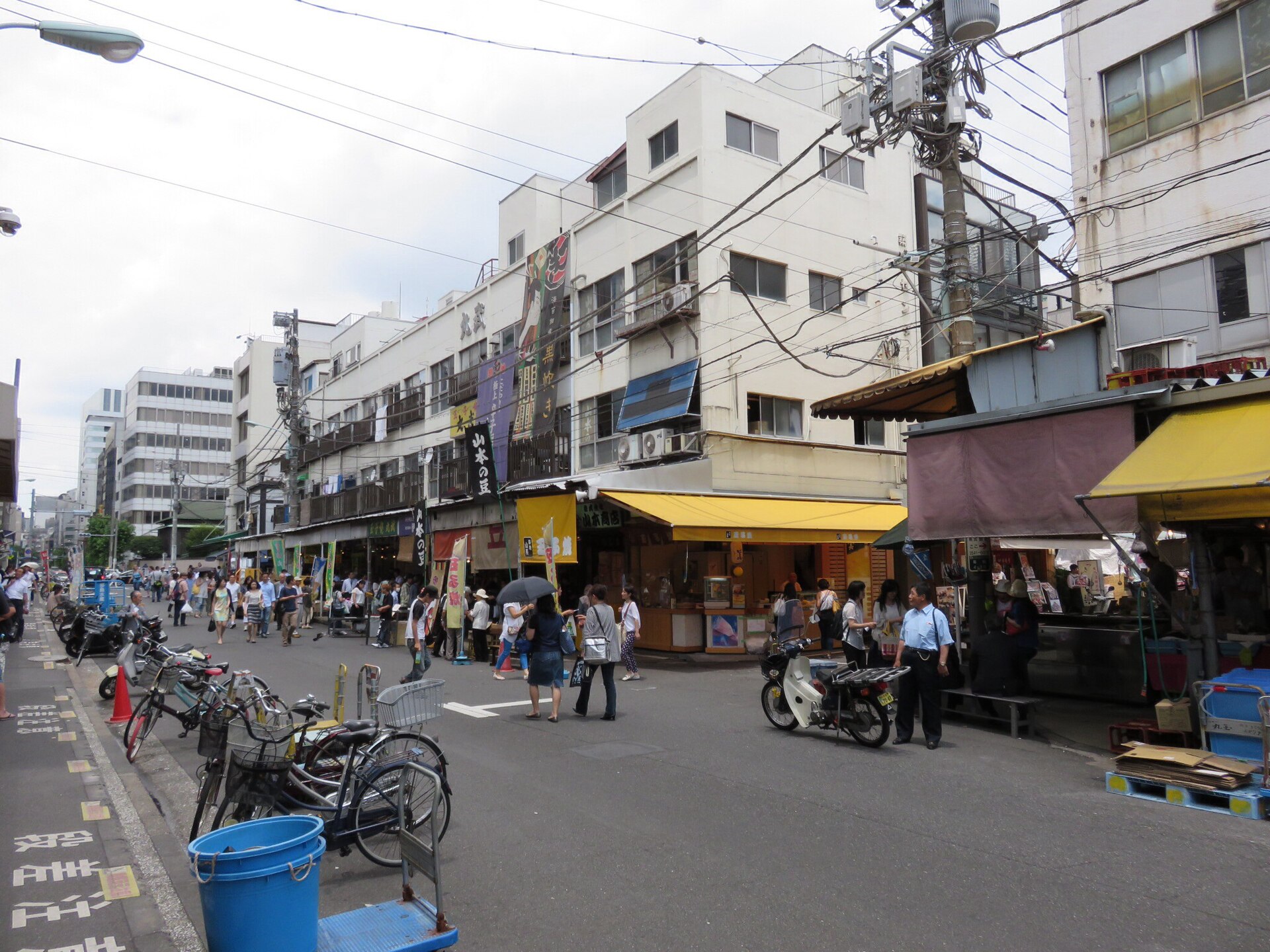 築地場外市場の通り。店の日よけやのぼりが並び、買い物客が行き交う(写真:Aw1805 / Wikimedia Commons / CC BY-SA 3.0)