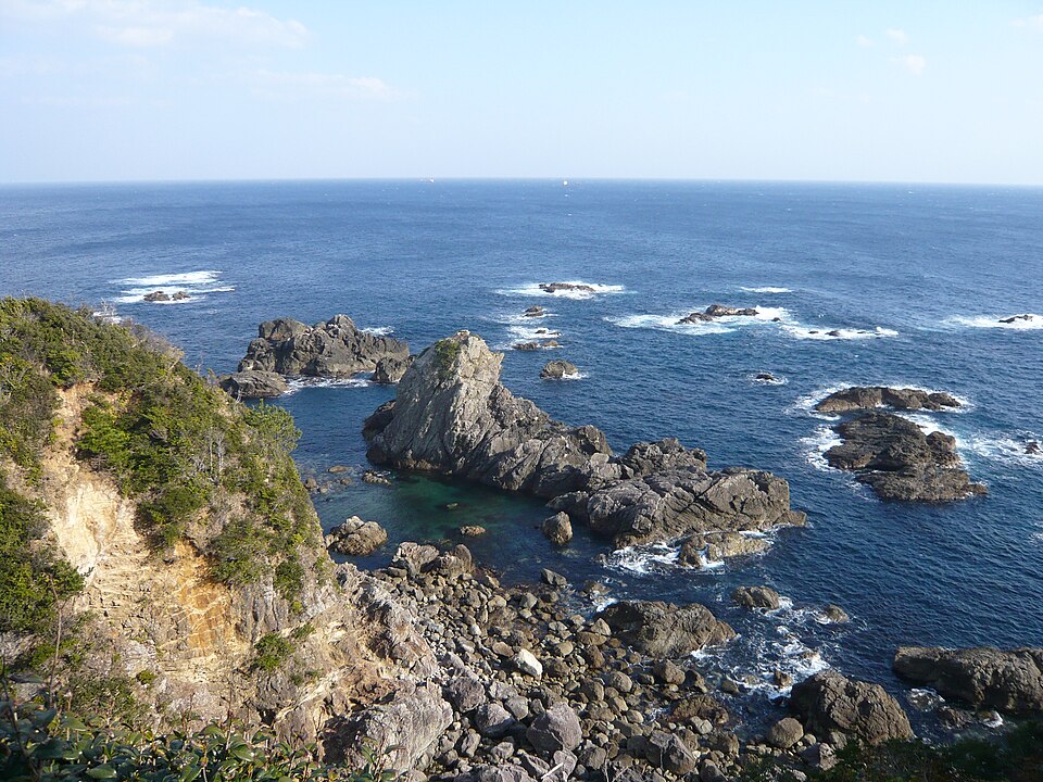 紀伊大島・トルコ記念館の直下の海岸。青い海にとがった岩と岩礁が点在する。エルトゥールル号が乗り上げた場所。写真:Opqr / Wikimedia Commons / CC BY-SA 3.0(2014年1月1日撮影)
