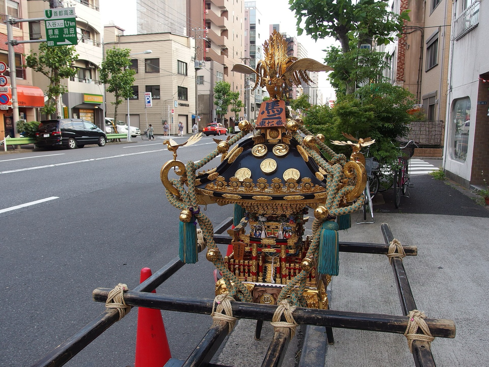 A neighbourhood mikoshi from the Sanja Matsuri rests on its wooden stand in a street in Asakusa, decorated with a golden phoenix, braided cords and tassels. Photo: Guilhem Vellut / Wikimedia Commons / CC BY 2.0 (17 May 2014)